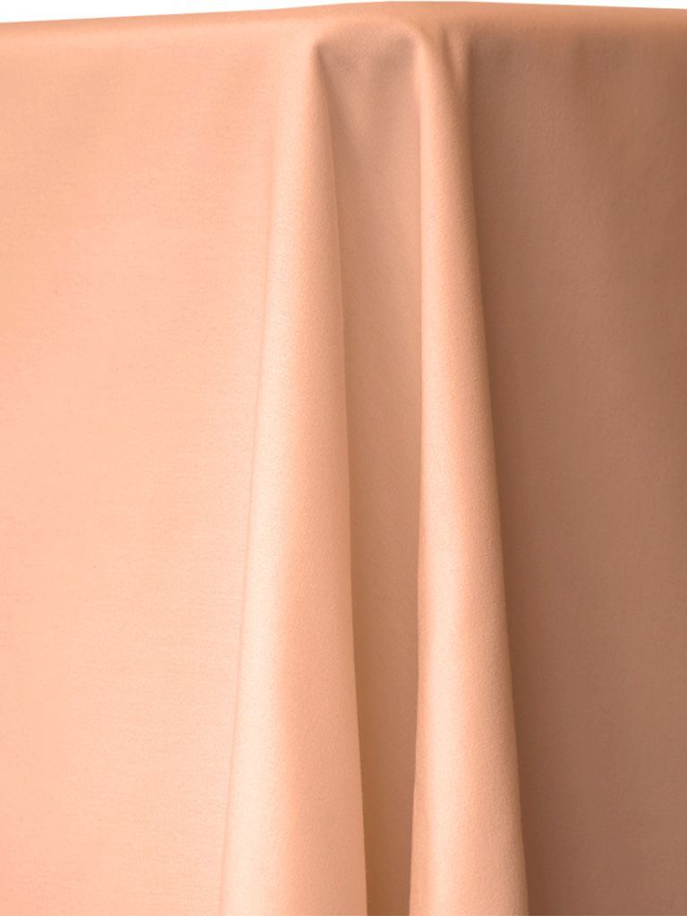 Peach-colored fabric draped over a surface, creating soft folds.