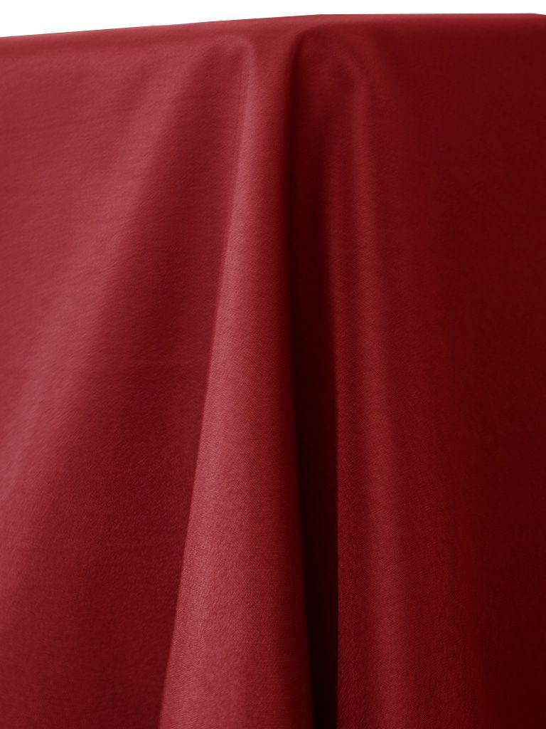 Burgundy fabric draped, showing folds and texture.