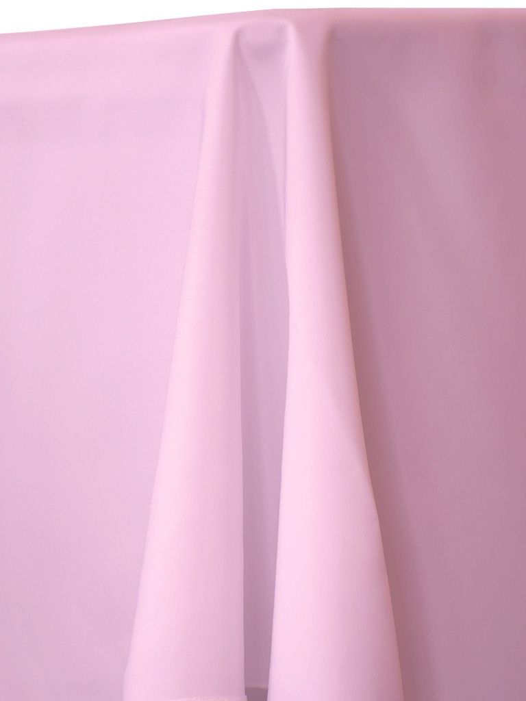 A light pink rectangular tablecloth draped over a table, with folds and shadows.