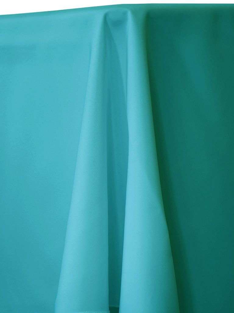 Aqua-colored tablecloth draped over a table, with folds and shadows creating depth.