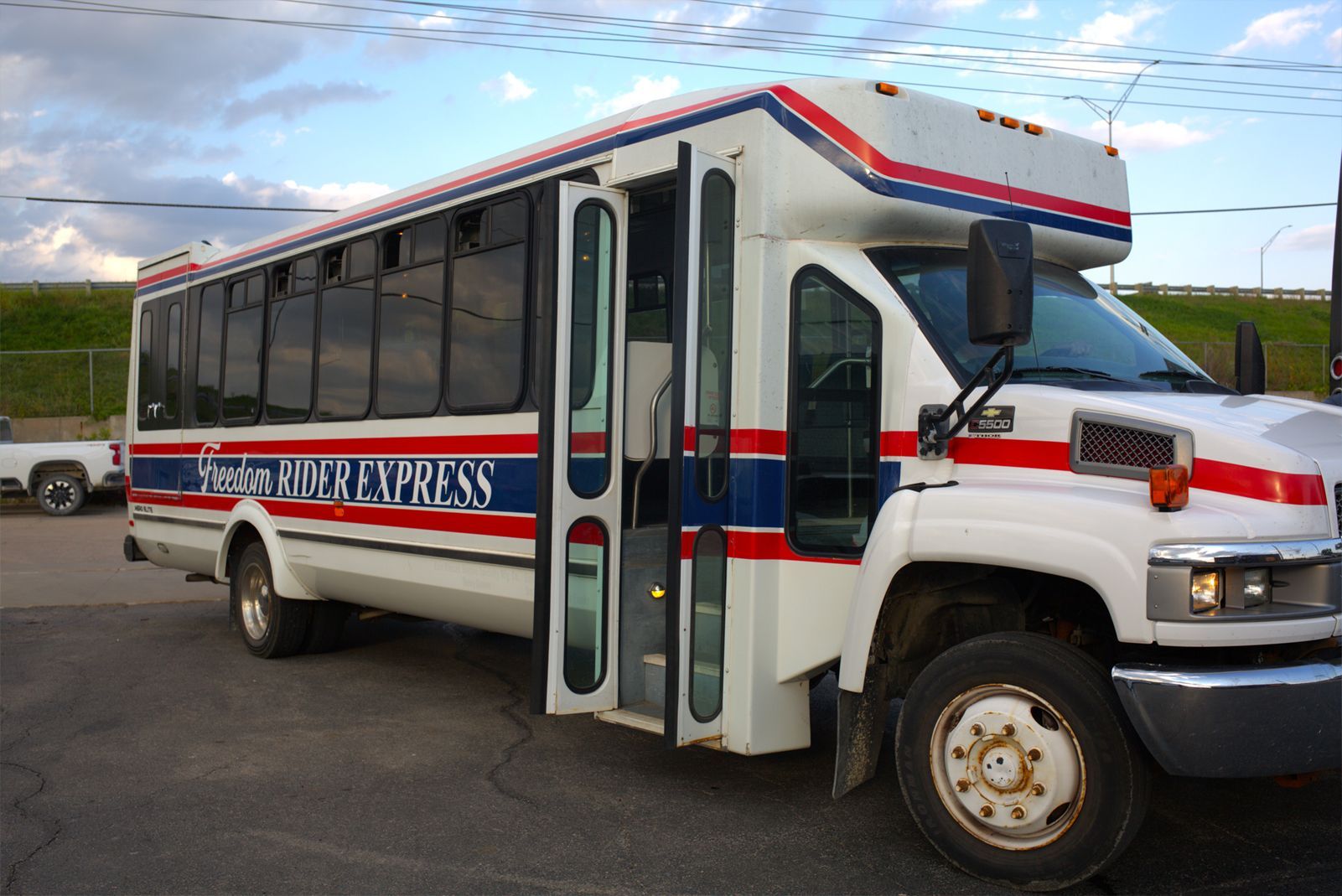 White passenger bus with blue and red stripes.