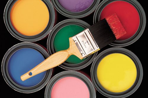 Paintbrush over open cans of colorful paint: yellow, orange, green, blue, pink, red, and yellow