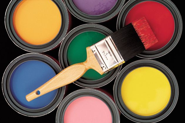 Paintbrush over open cans of colorful paint: yellow, orange, green, blue, pink, red, and yellow