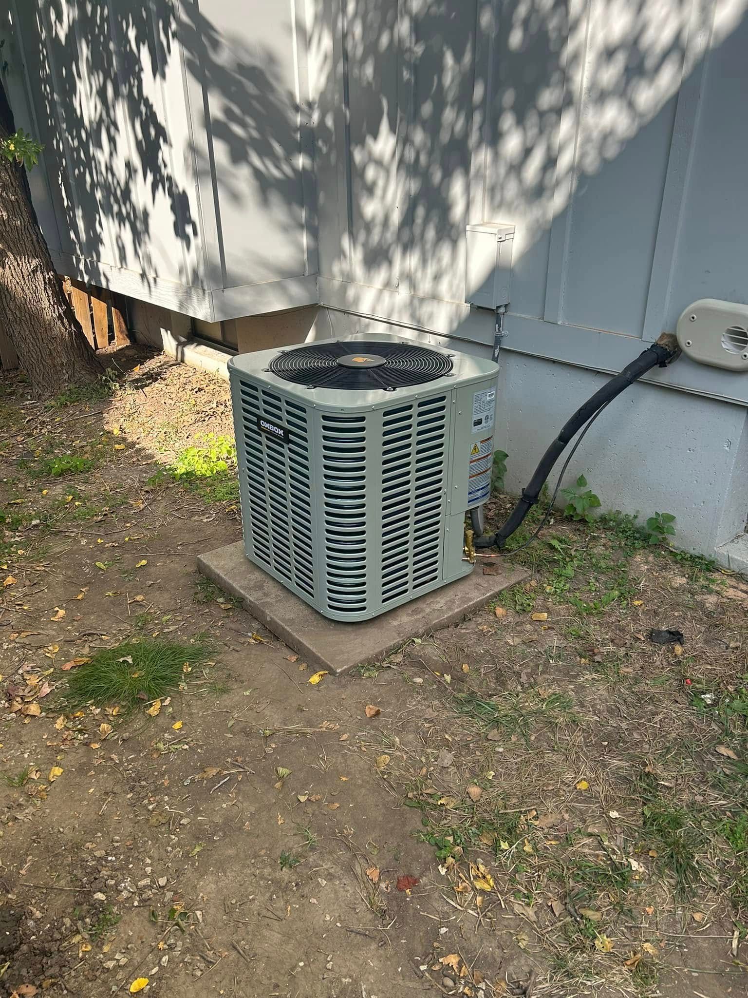 Air conditioning unit outside a building on a concrete pad.