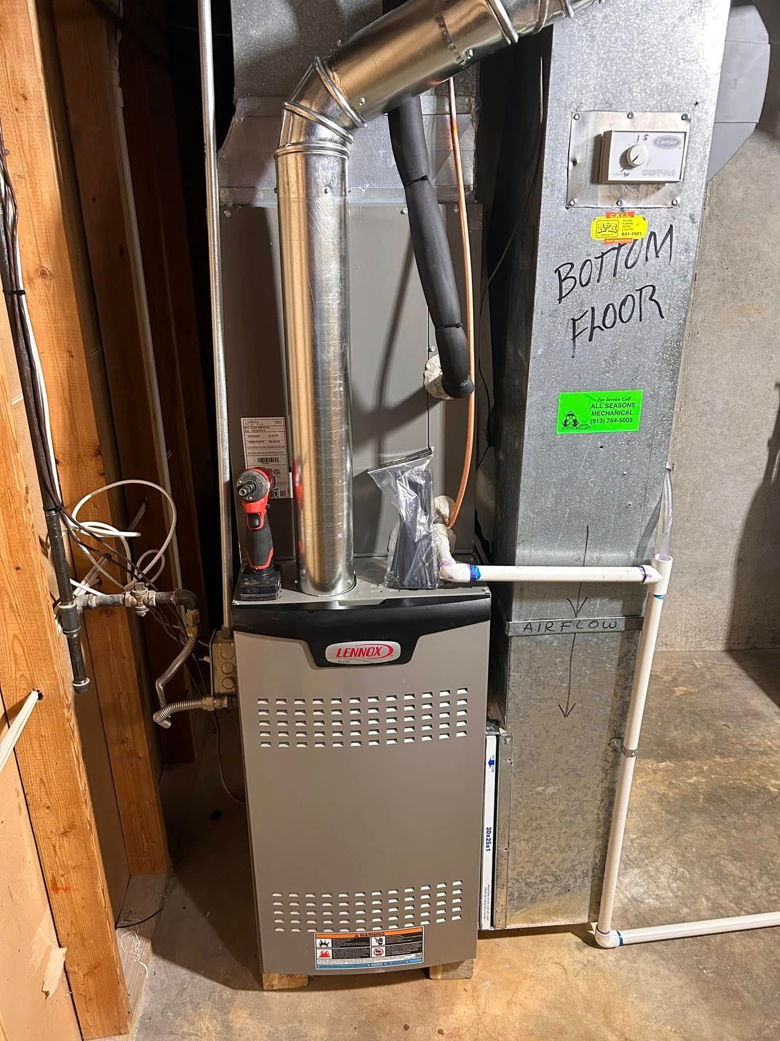 A silver Lennox furnace with metal ductwork in a utility room.