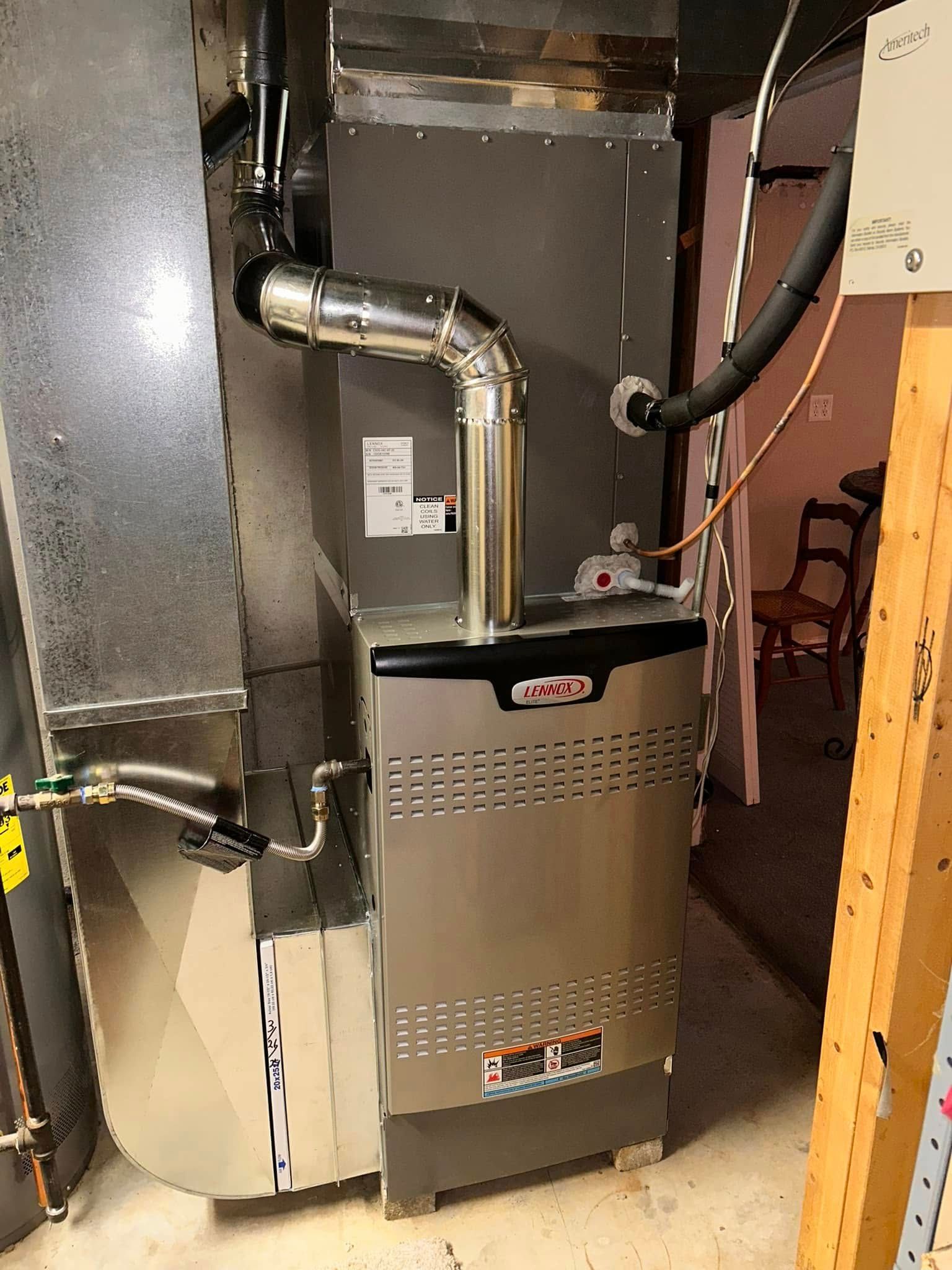 A silver Lennox furnace with ductwork in a basement.
