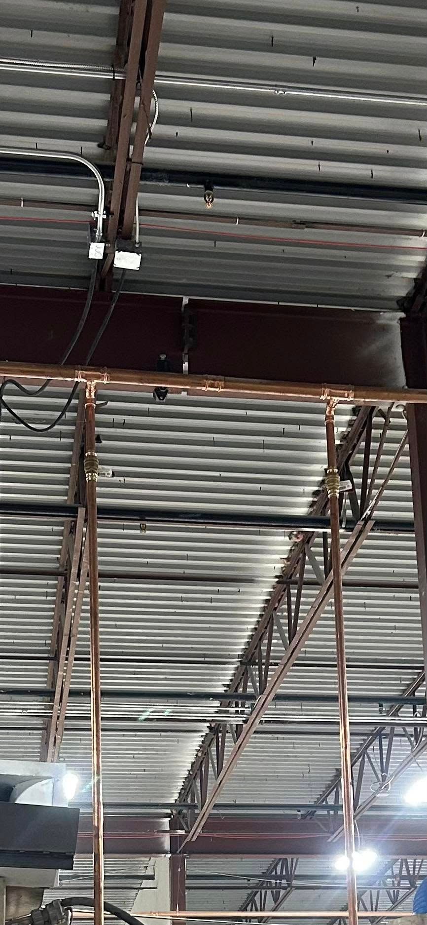 View of corrugated metal ceiling and metal scaffolding.
