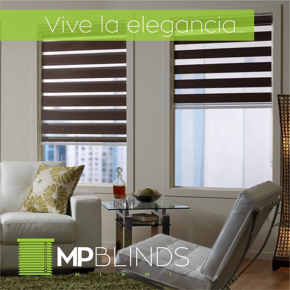 Living room with zebra blinds; white furniture, cityscape view, and the text