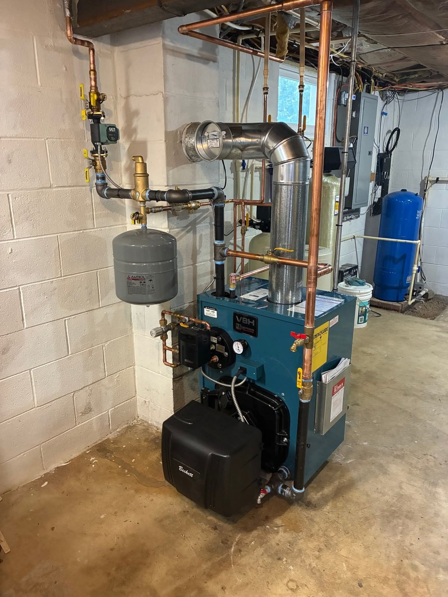 A boiler and associated plumbing in a basement setting.