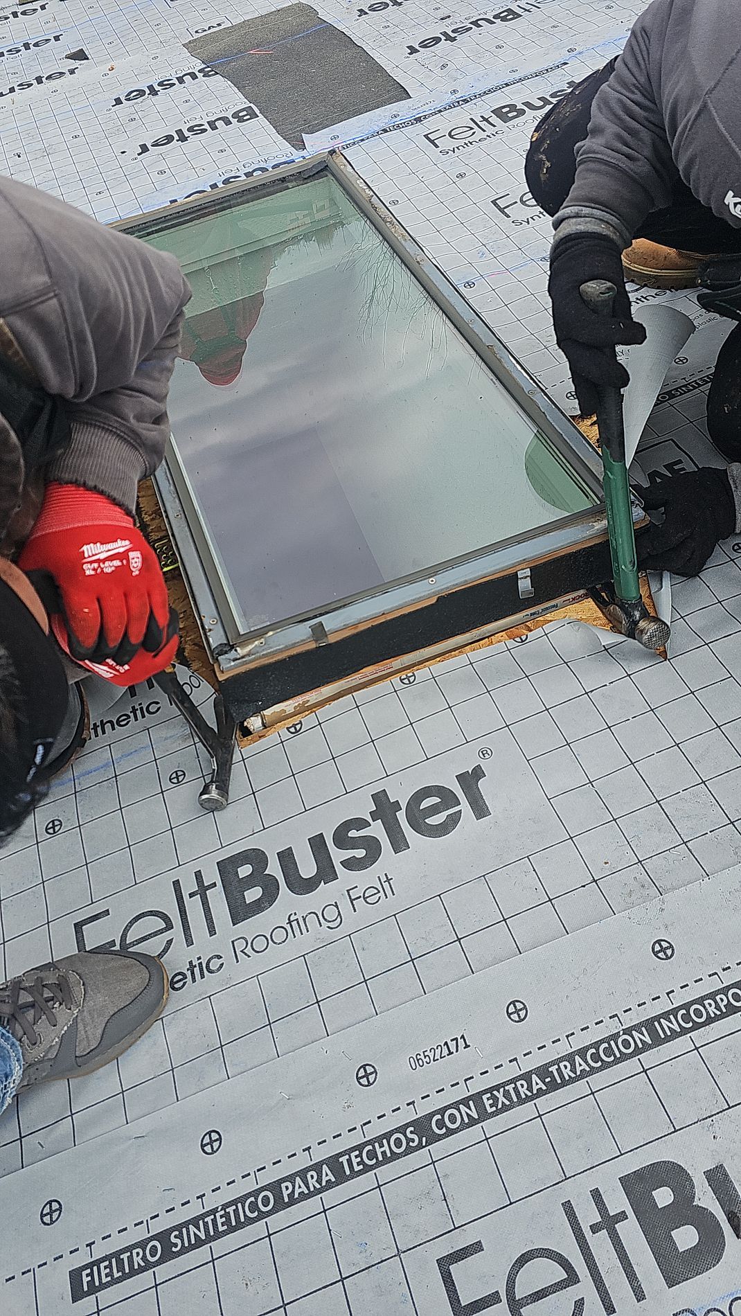A man is installing a skylight on during a roof replacement in Clive, IA