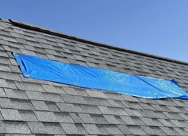 Storm damaged roof inspection with blue tarp to protect the interior in Ankeny, IA.
