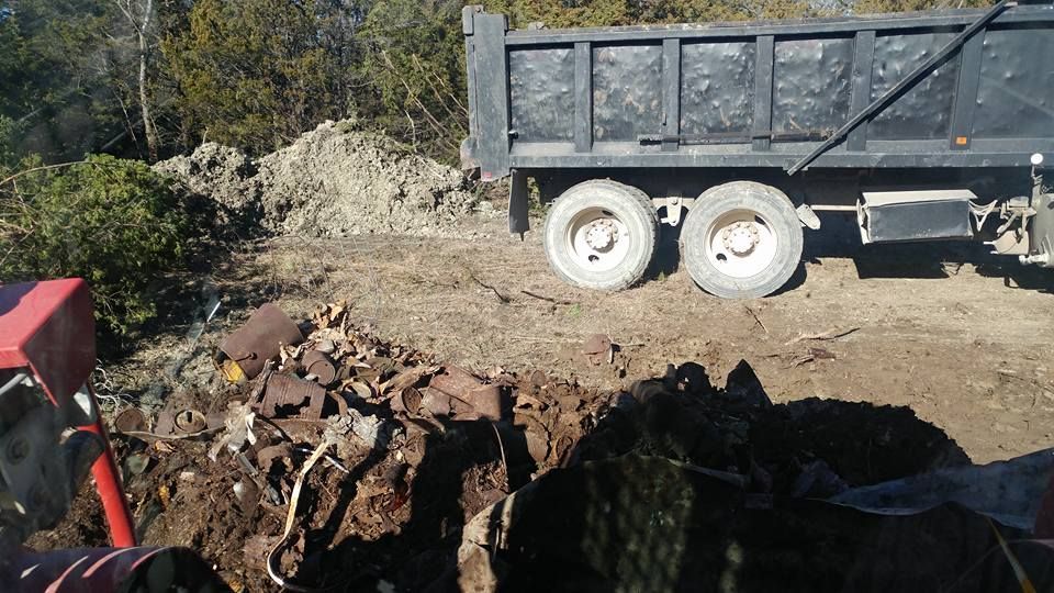 A dump truck is driving down a dirt road