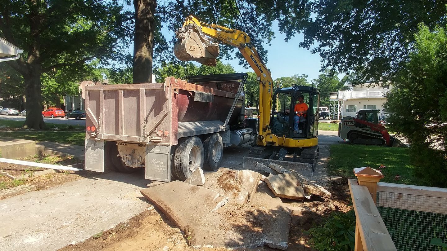 A yellow excavator is loading dirt into a dump truck