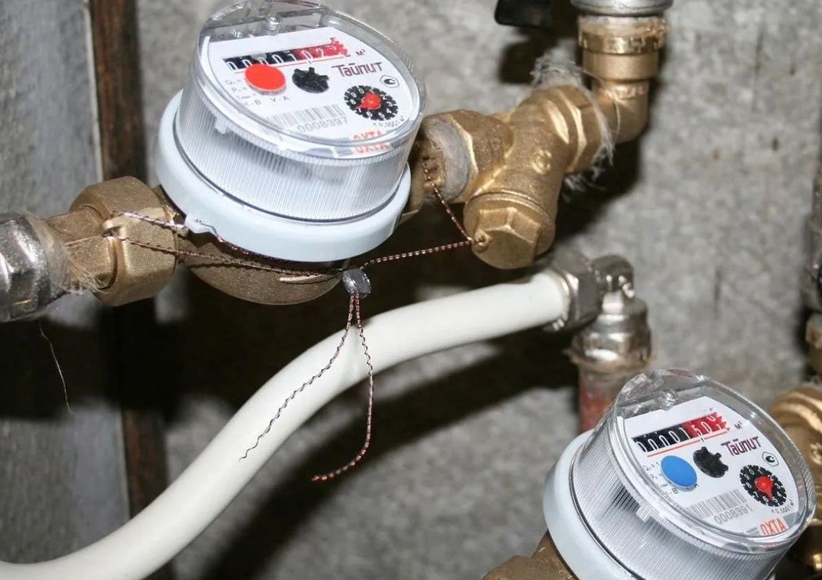 Two water meters are connected to a pipe and one has the word safety on it