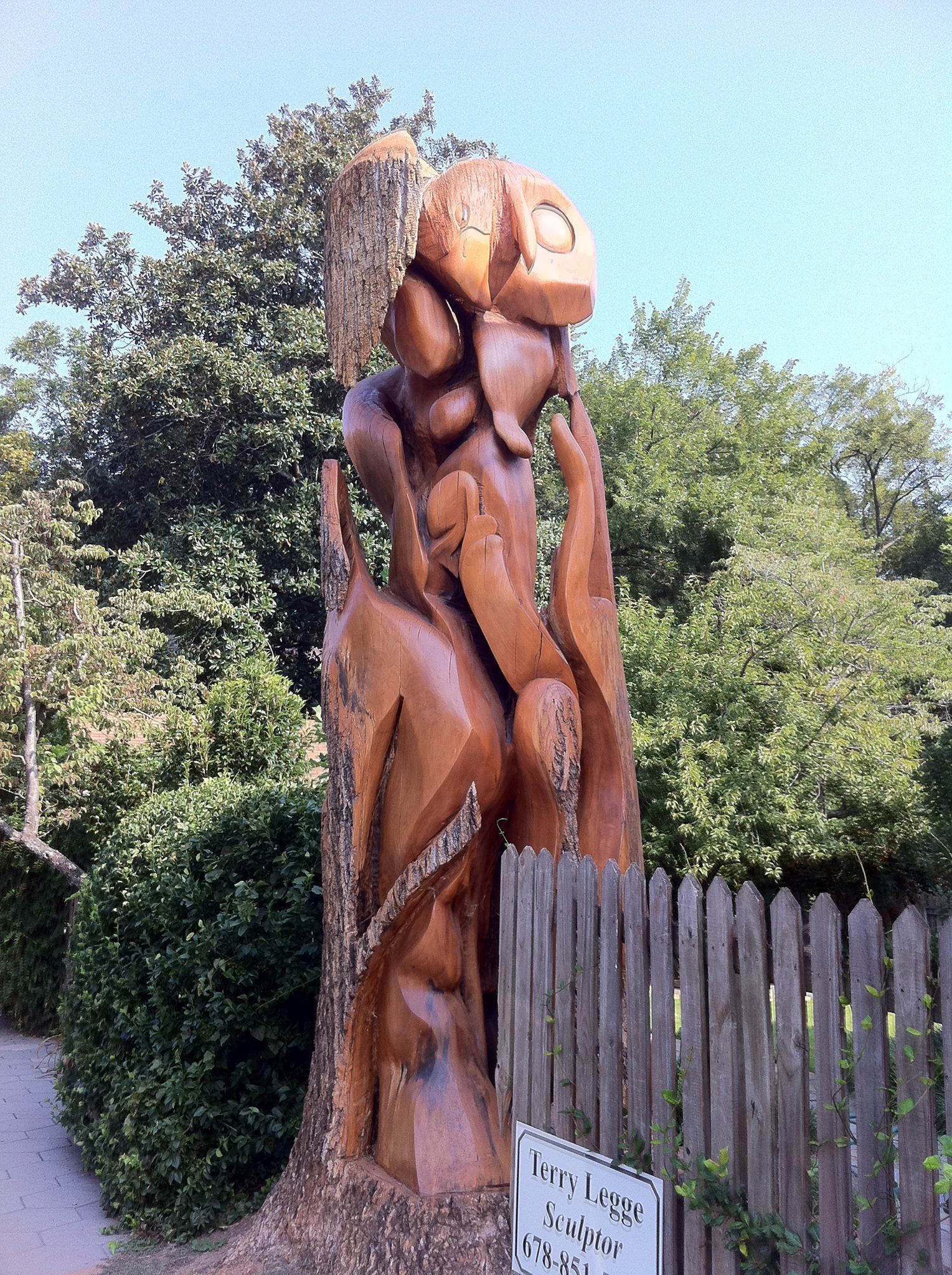 A wooden statue of a man standing next to a sign that says rules