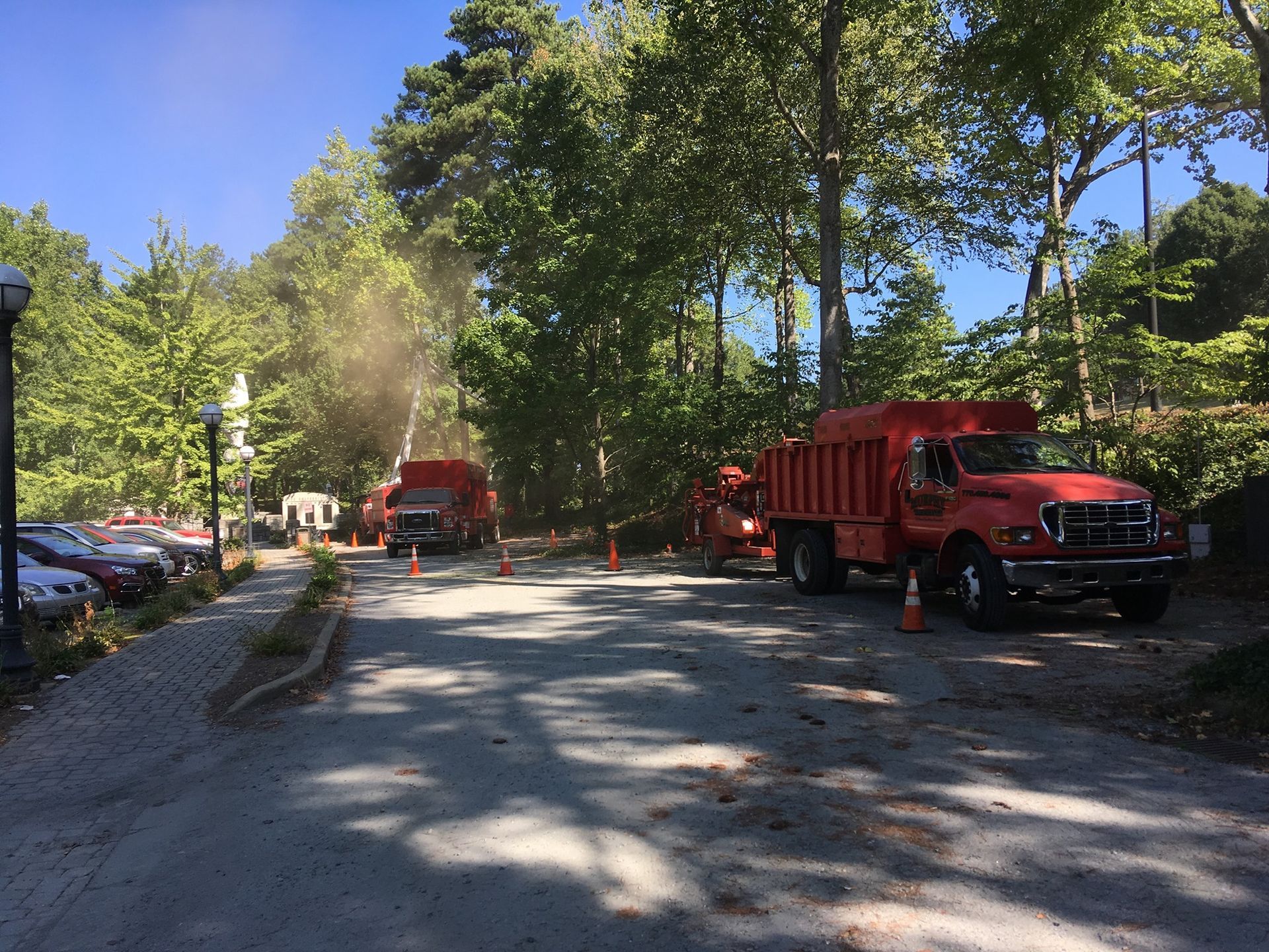 Two red trucks are parked on the side of the road
