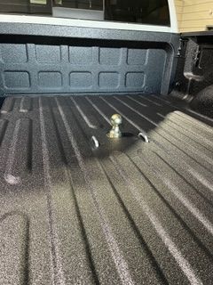 Truck bed with a gooseneck hitch ball. The bed has a textured coating.
