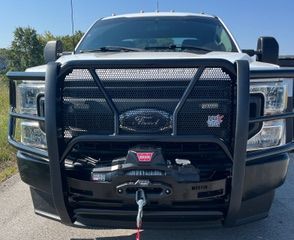 White Ford truck with black grill guard and winch.