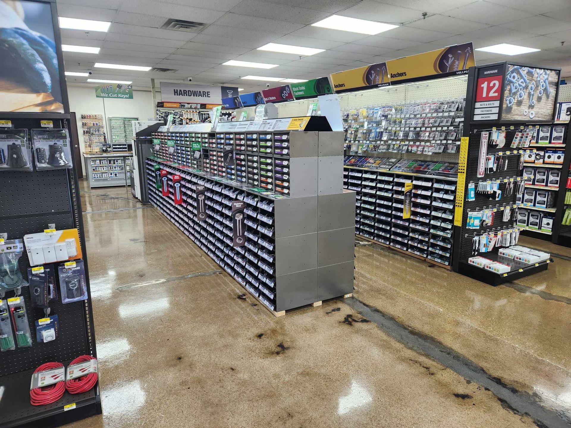The inside of a hardware store with a lot of shelves and a counter.
