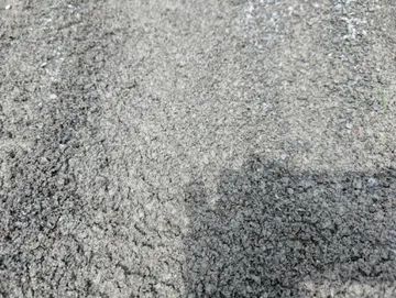 Close-up view of gray, grainy material, possibly sand or small gravel.