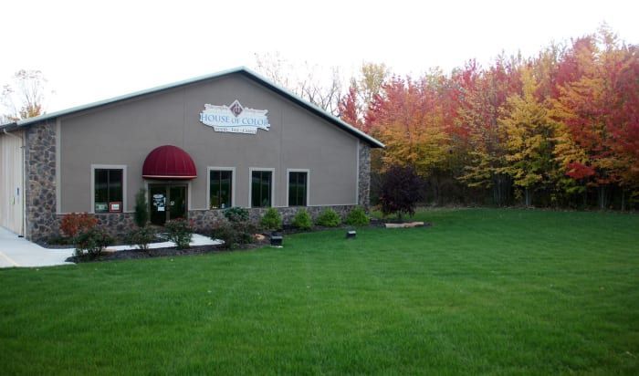 A large building with a red awning and a lush green lawn in front of it.