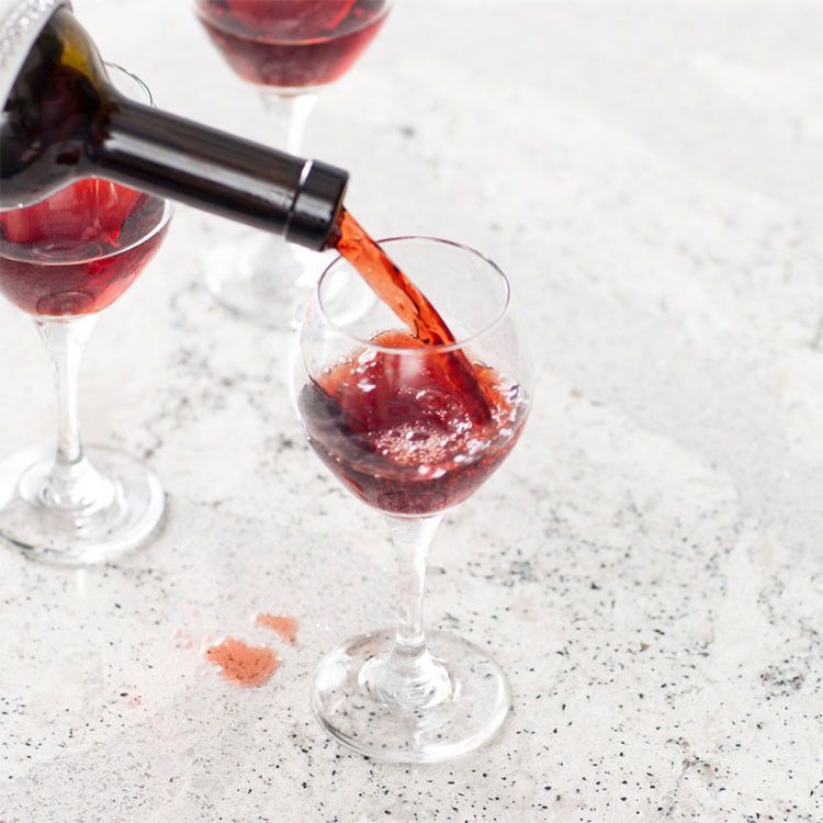 A bottle of wine is being poured into a wine glass