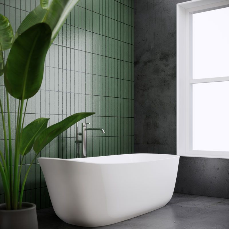 A white bathtub in a bathroom next to a window