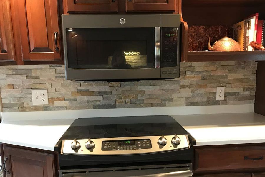 A kitchen with a stove and a microwave above it