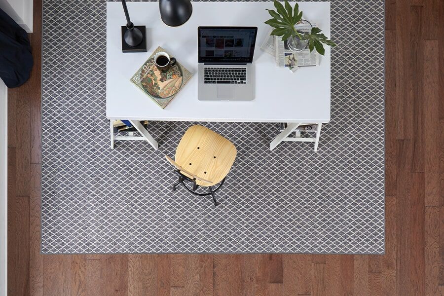An aerial view of a home office with a laptop on a desk.