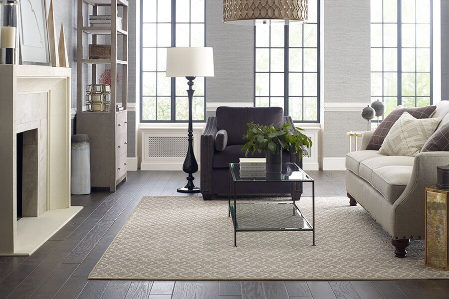 A living room with a couch , chair , coffee table and fireplace.