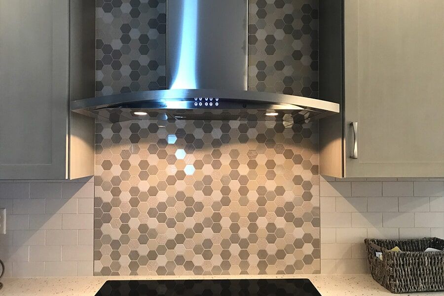 A kitchen with a stove top oven and a stainless steel hood