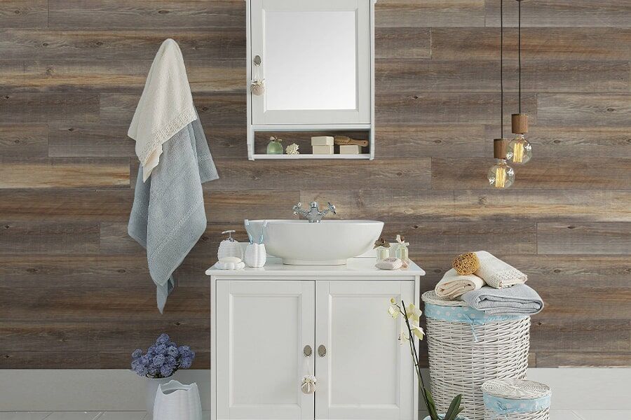 A bathroom with a sink , mirror , cabinet , and laundry basket.