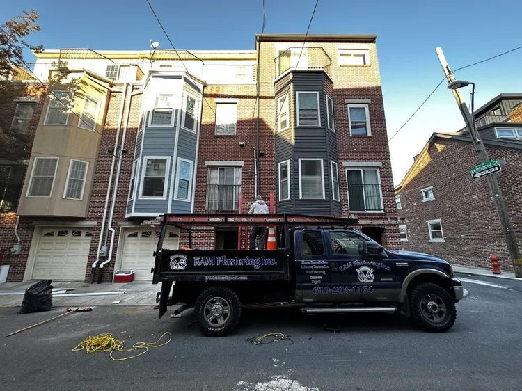 Truck parked in front of brick building with bay windows; 