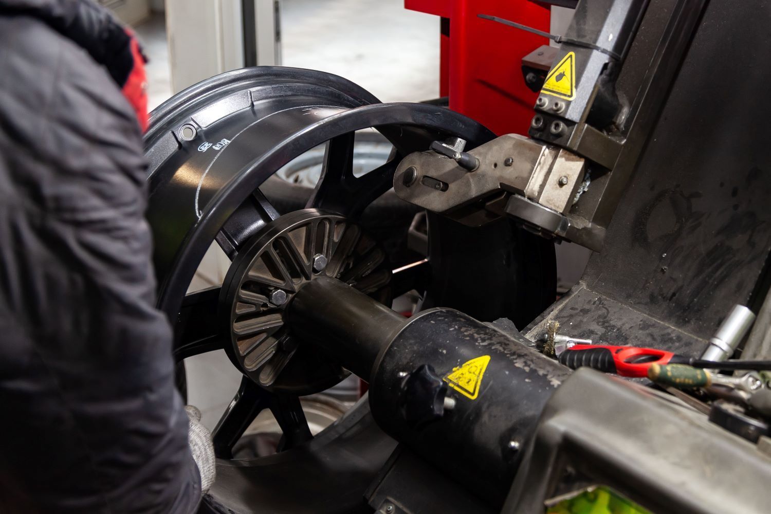 A person is working on a machine that is cutting a tire.
