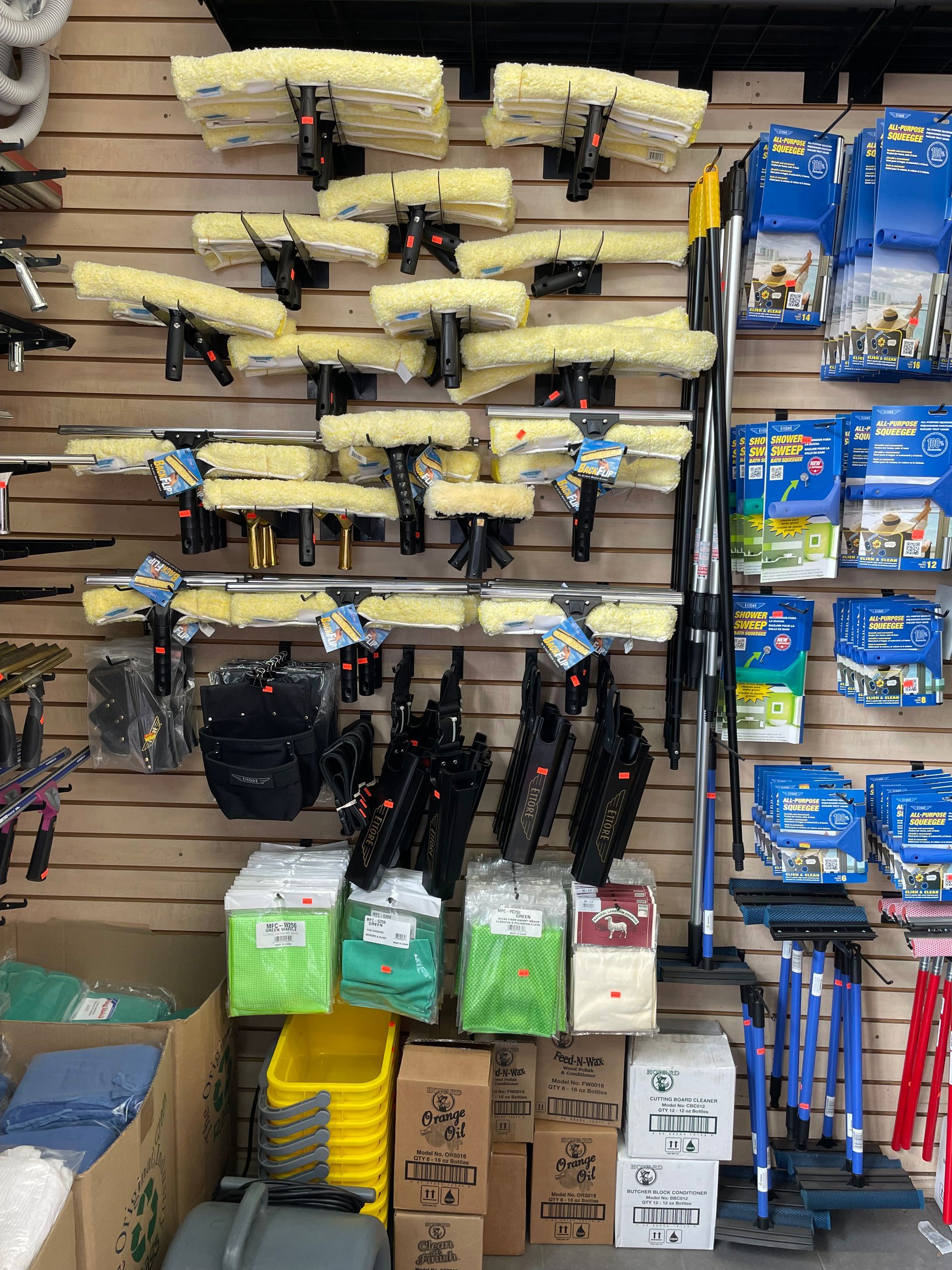 Cleaning supplies displayed in a store. Many window cleaning squeegees, buckets, soap, and tools are present.