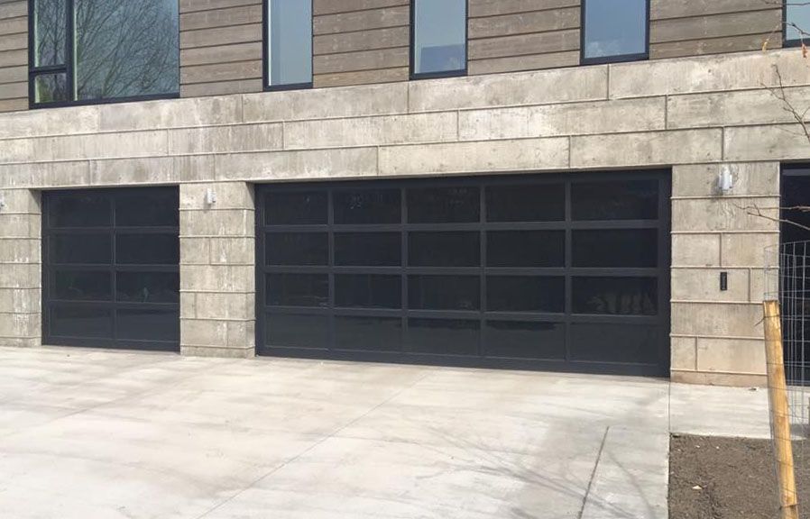 There are three garage doors on the side of a building.