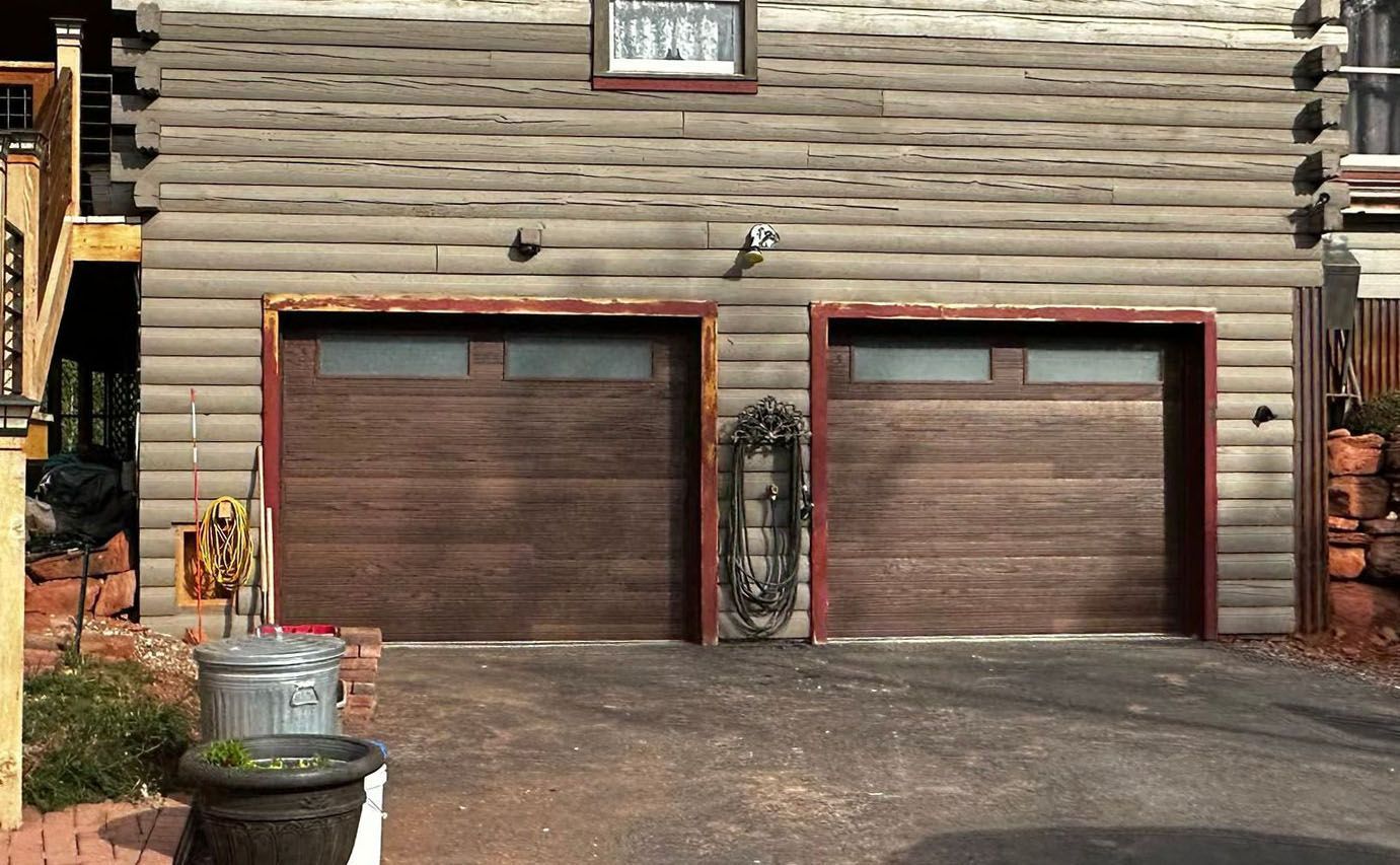 A log cabin with two garage doors and a window