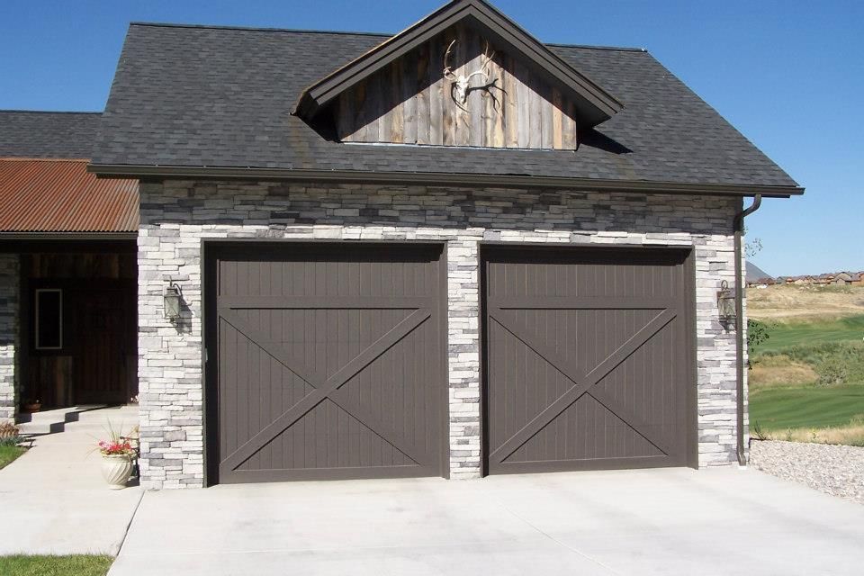 A house with two garage doors and a wooden roof