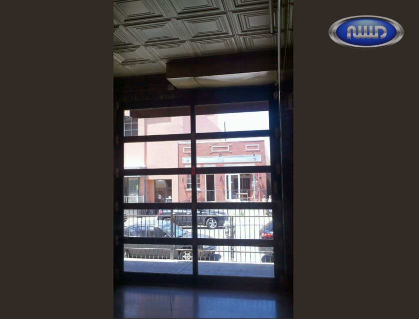 Glass door overlooking city street with parked cars.