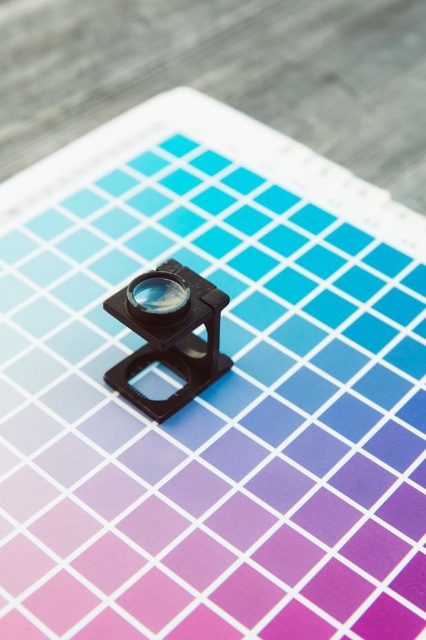 A magnifying glass is sitting on top of a color chart