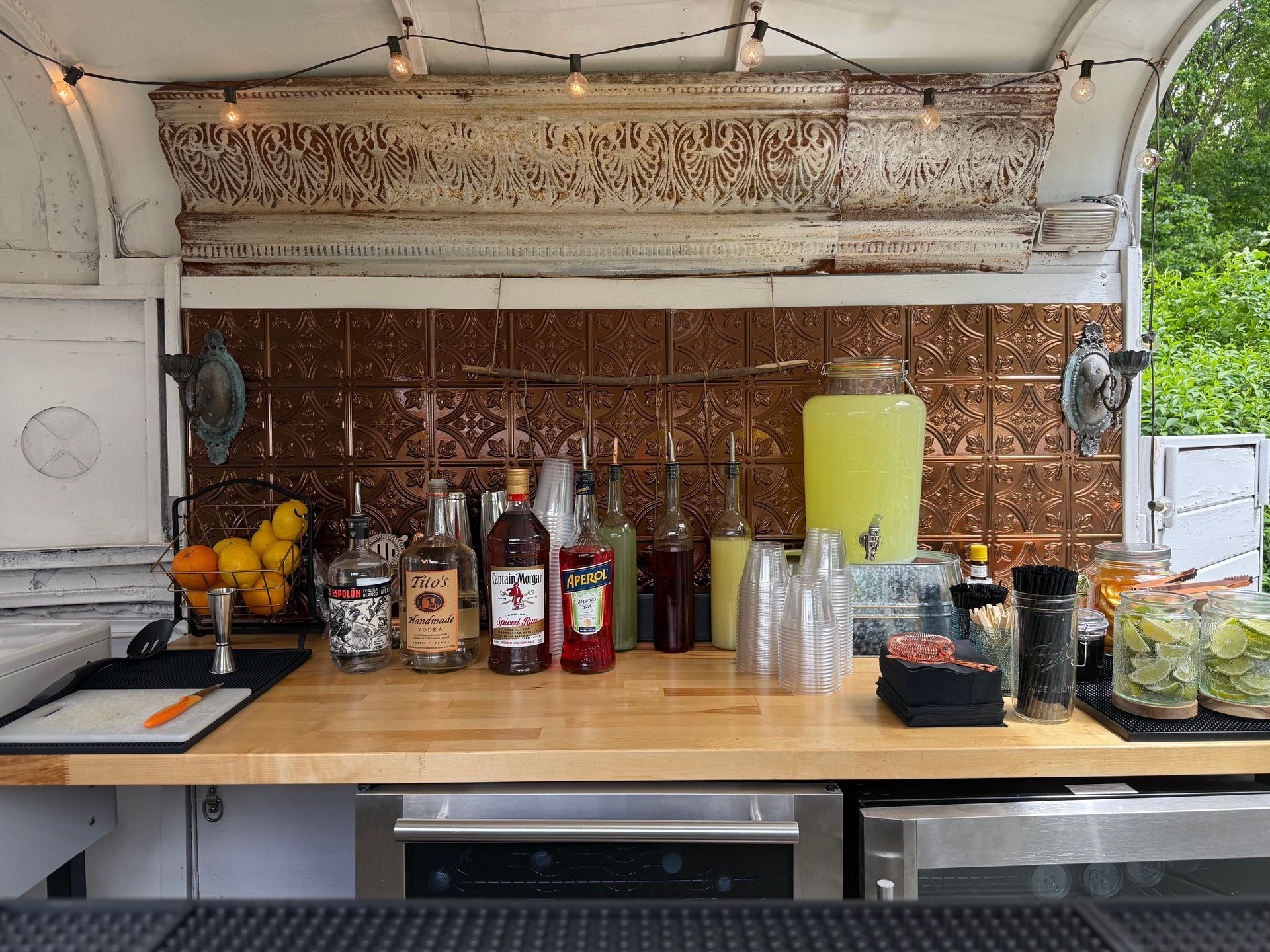 A white trailer is parked in a grassy field next to a rocking chair.