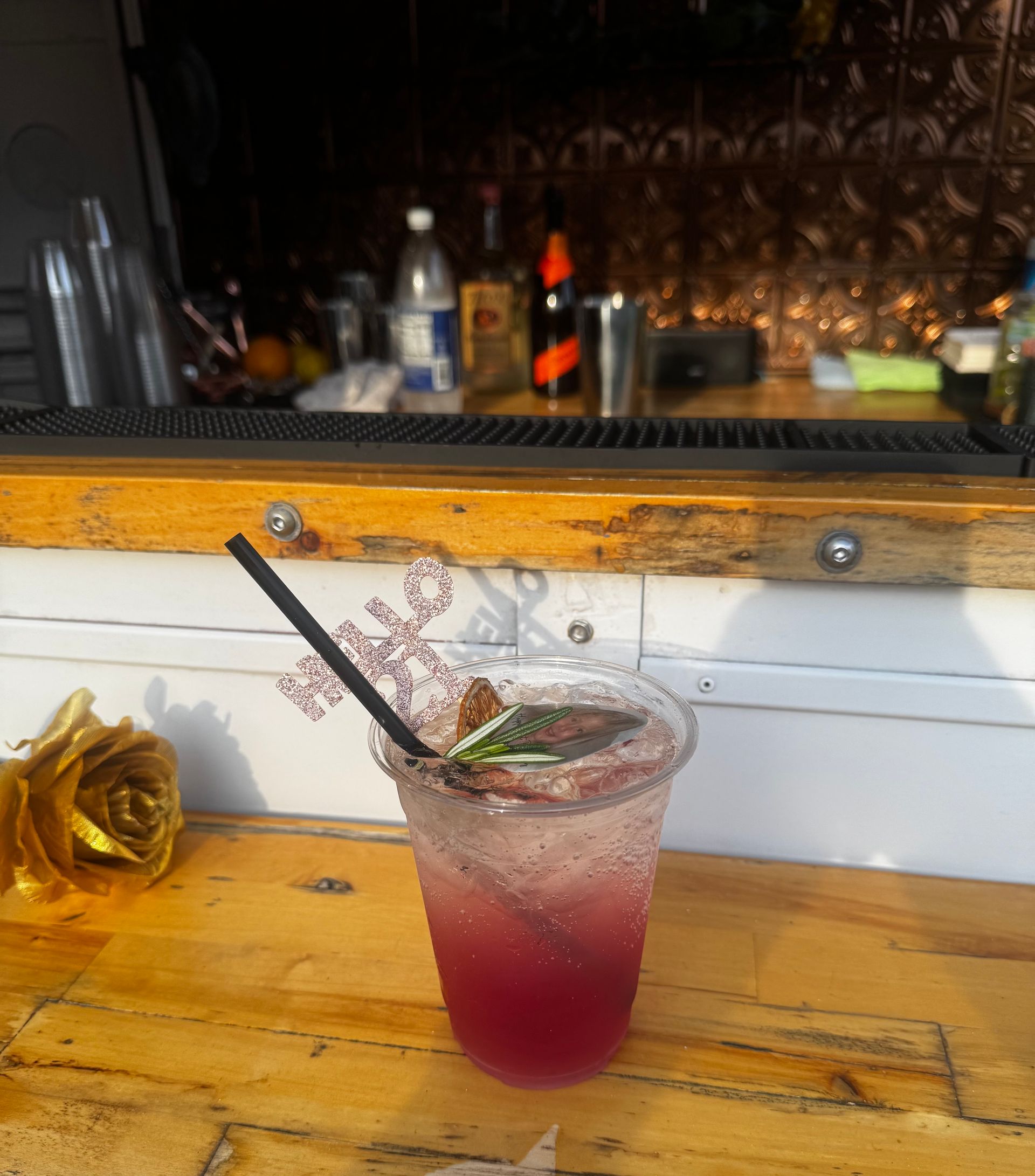 A drink in a plastic cup with a straw on a wooden table