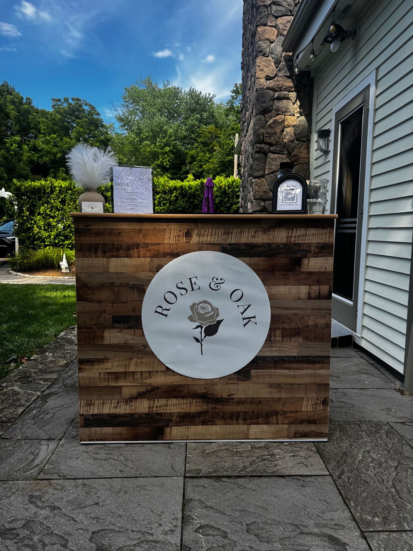 A rustic wood bar set outside a stone building.