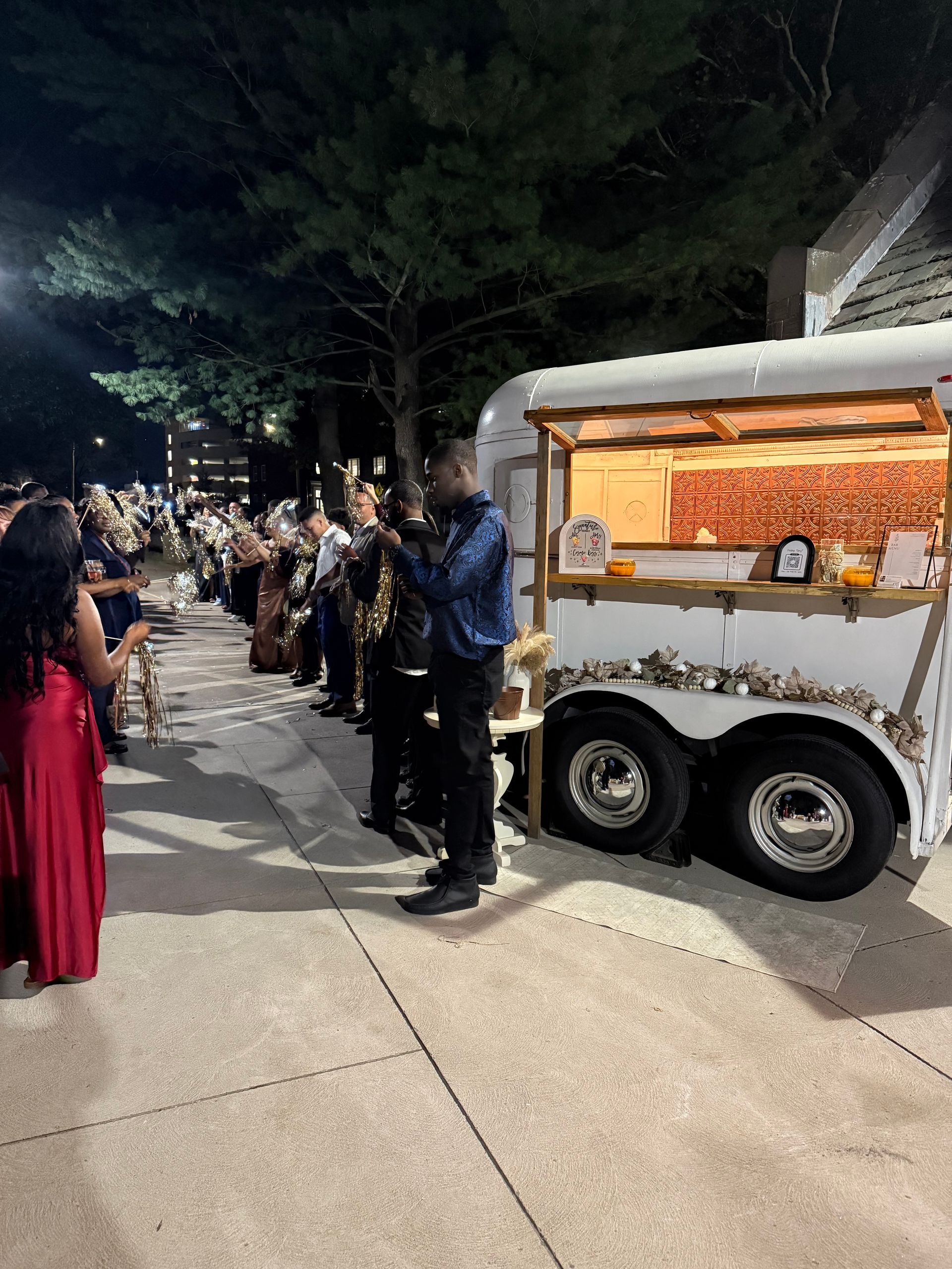 A band playing music near a food truck at an outdoor event, with people watching.