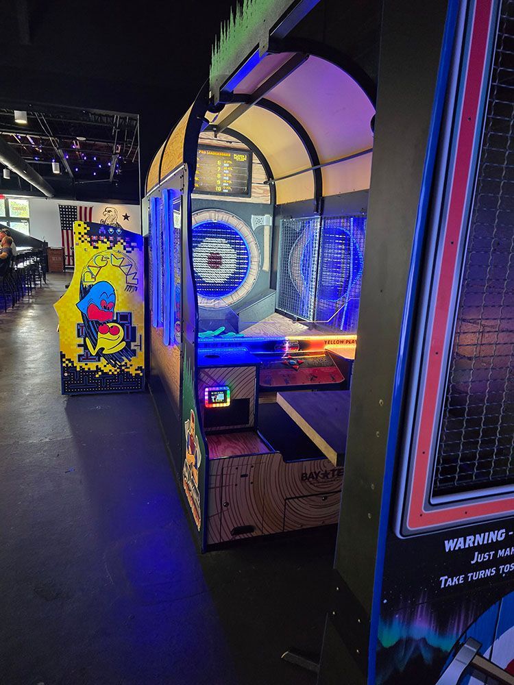 Arcade game resembling a covered wagon, with blue and purple lighting inside