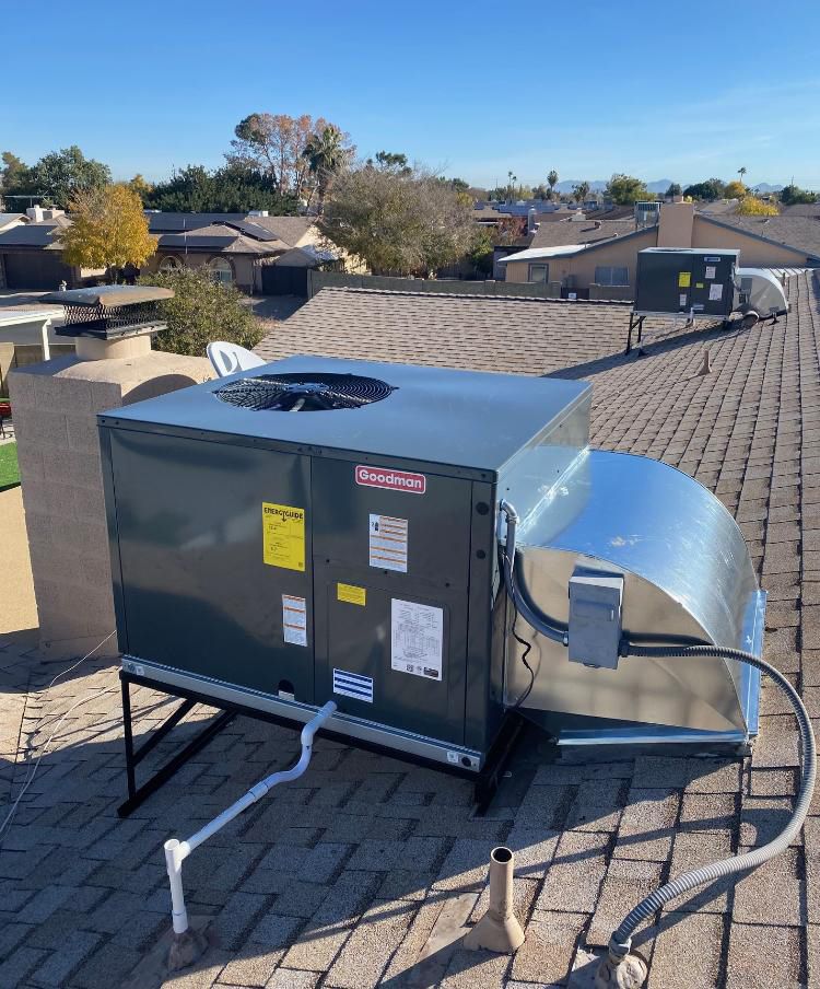 An air conditioner is sitting on top of a brick roof.