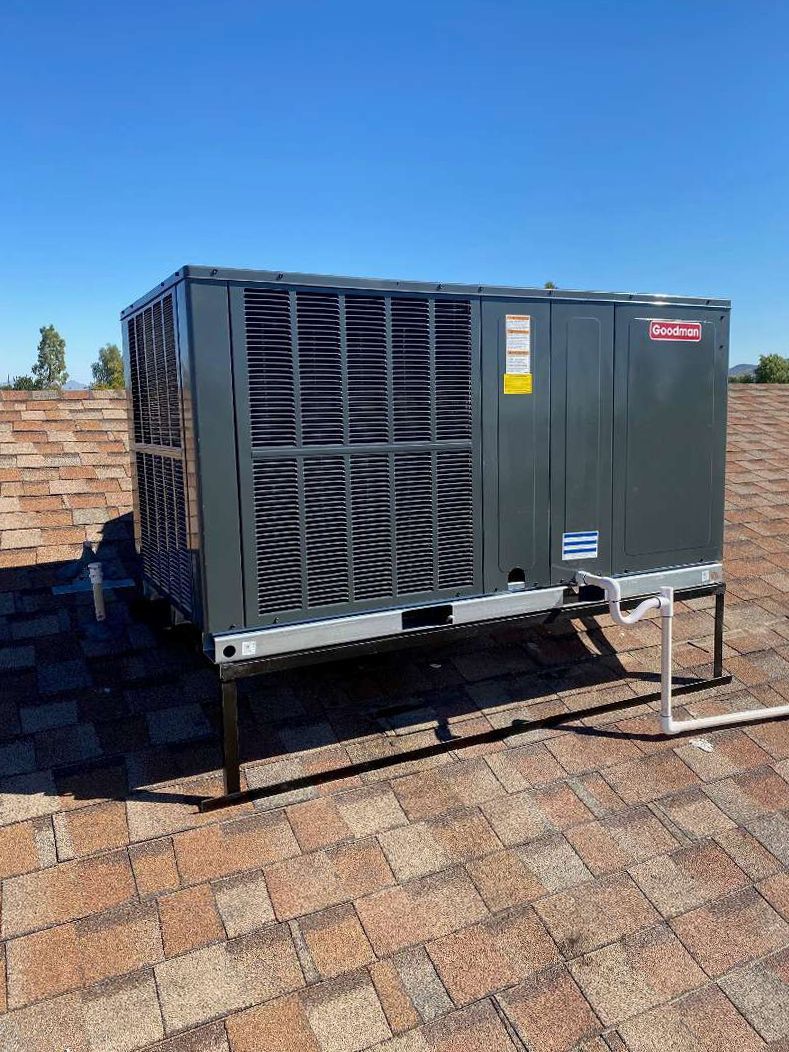 A large air conditioner is sitting on top of a brick roof.