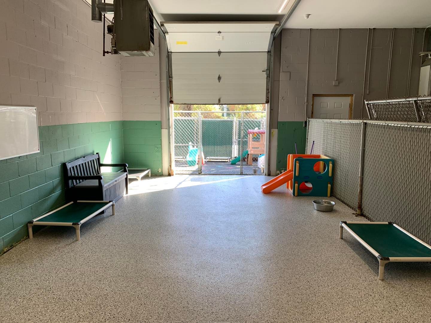 A large room with lots of beds and a playground.