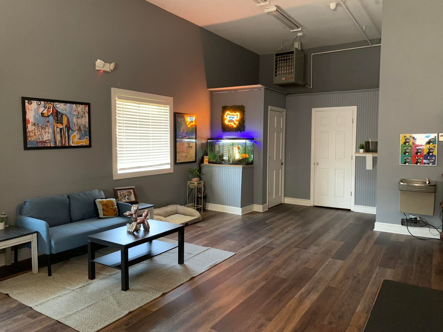 A living room with a blue couch , coffee table , and aquarium.