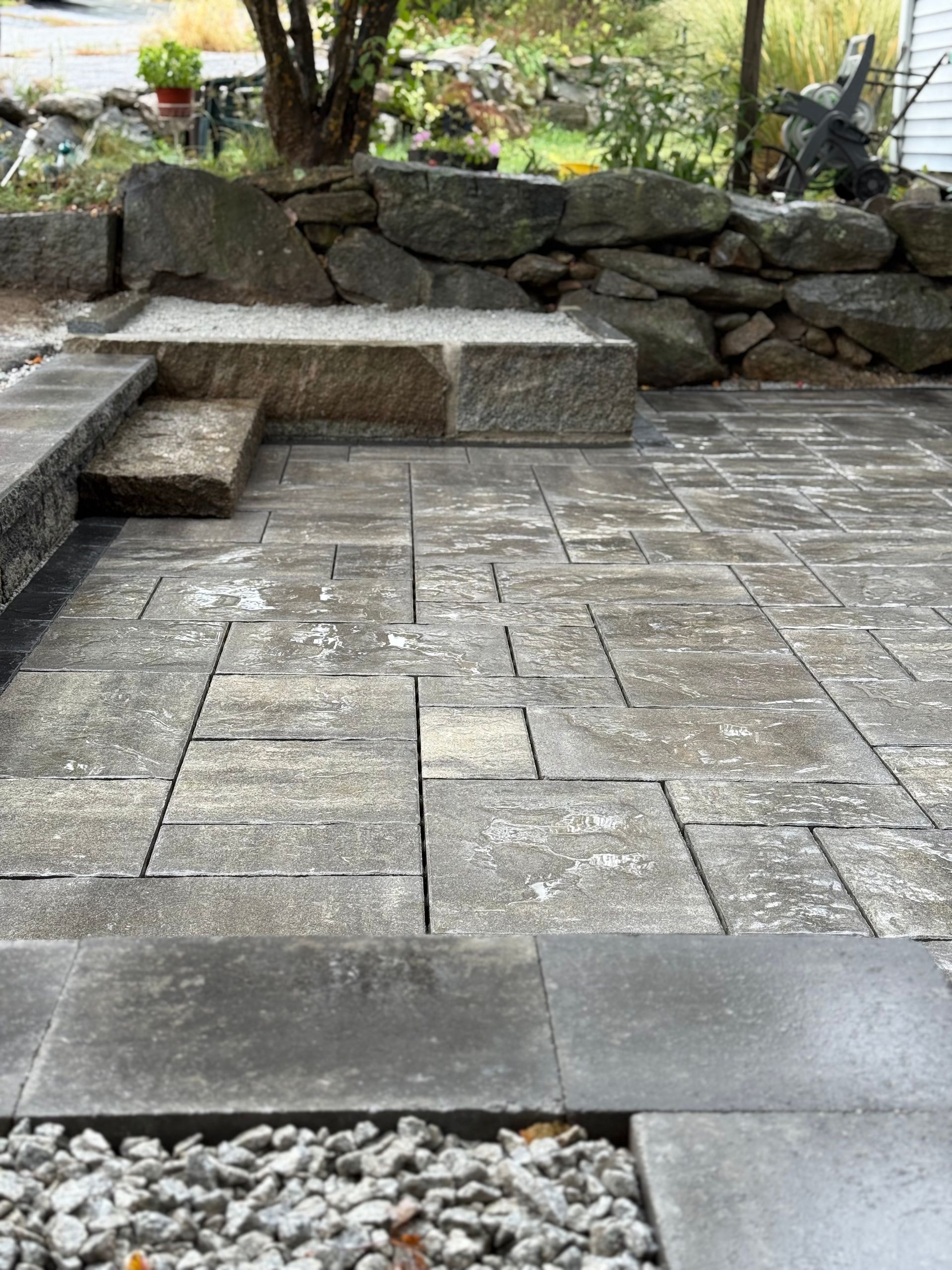 Stone patio with built-in bench in a landscaped outdoor garden area